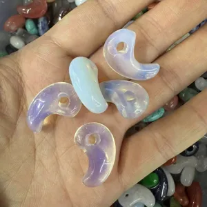 Close-up view of opalescent magatama comma-shaped stone pendants for DIY jewelry making.