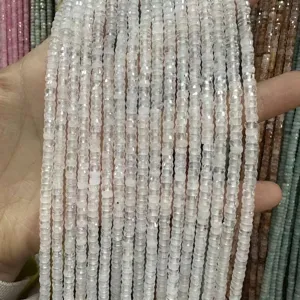 Primer plano de cuentas de piedra natural blanca tallada de 2x4mm para accesorios de joyería DIY.