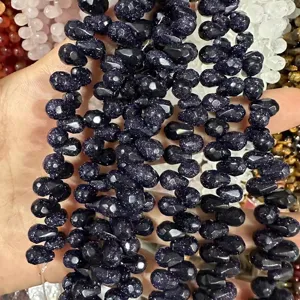 Gros plan sur des perles en pierre de sable bleu facettées en forme de goutte pour DIY