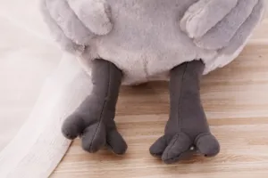 Gros plan détaillé montrant les pieds en tissu gris doux et la texture moelleuse en peluche.