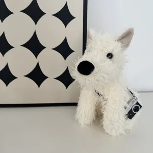 Adorable white terrier plush toy with miniature camera accessory, soft stuffed animal gift.