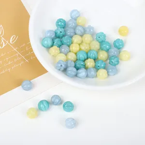 Close-up of ridged pumpkin-shaped loose beads in pastel blue and yellow for DIY jewelry
