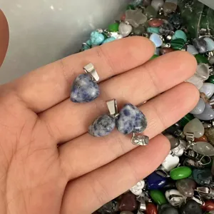 Detailansicht von 12 mm herzförmigen Anhängern aus blauem Naturstein in der Hand