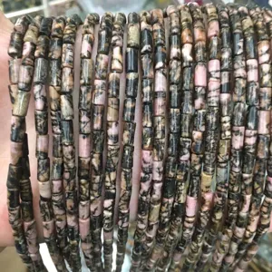 Detailed view of 4x7mm pink and black natural stone cylinder beads for DIY jewelry making