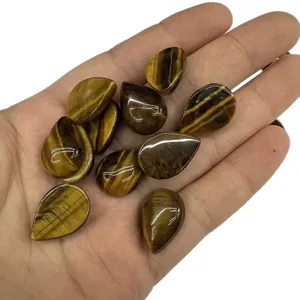 Handheld collection of natural teardrop tiger eye stone cabochons for DIY jewelry making