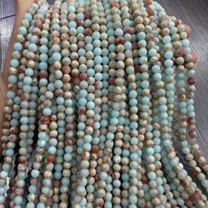 Primer plano de cuentas redondas de piedra Shoushan natural azul y marrón para bisutería
