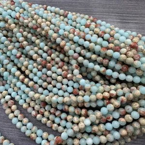 Primer plano de cuentas redondas de piedra Shoushan azul claro con vetas marrones naturales