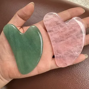 Vue rapprochée de pierres de gua sha en quartz rose et aventurine verte naturelle