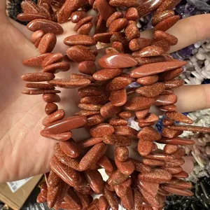 Detailopname van onregelmatige goudsteen kralen in lange tandvorm met gouden glitters.