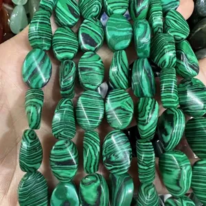 Dettaglio macro di perle in pietra malachite verde ovale con motivi a strisce per gioielli