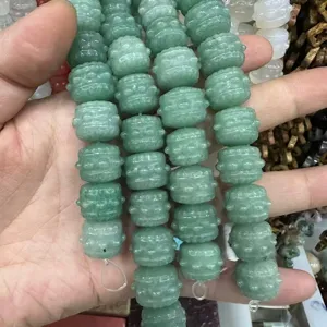 Detailed view of green natural stone drum-shaped carved beads for DIY jewelry design
