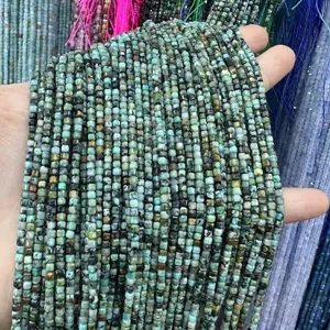Makro-Detail von 2,5 mm facettierten quadratischen grünen Natursteinperlen für DIY-Schmuck