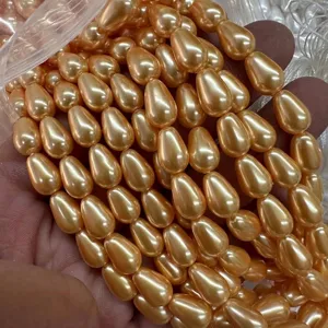 Gros plan de perles de nacre en forme de goutte champagne au fini lisse et lustré