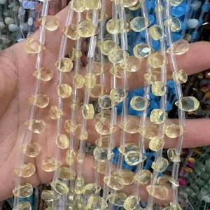 Primer plano de cuentas de piedra natural amarilla talladas para la creación de joyas.