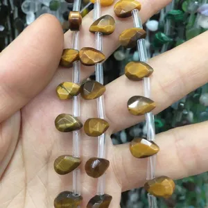 Primer plano de cuentas facetateas de ojo de tigre natural en forma de gota de agua para DIY