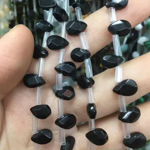 Vista macro detallada de cuentas de piedra natural negra facetada para joyería artesanal