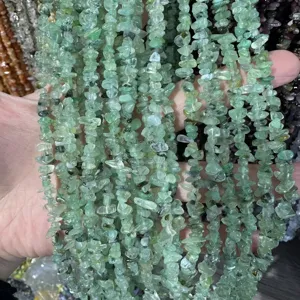 Detalle macro de cuentas de virutas de piedra natural verde claro de 3x5mm para joyería DIY