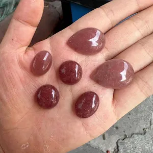 Close-up detail of natural strawberry quartz cabochons in round and oval shapes