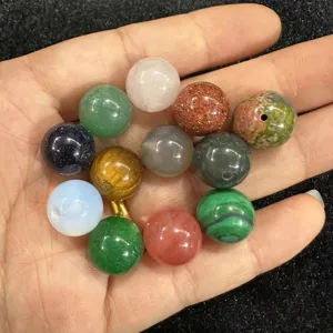 Collection of assorted natural stone and crystal round beads for DIY jewelry making held in hand