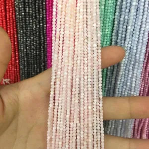 Close-up of 2mm pink round shell beads showing smooth texture and pearlescent luster.