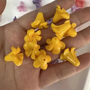 Macro view of bright yellow trumpet flower shaped acrylic beads for DIY jewelry crafts.