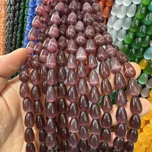 Detalle de cuentas de ojo de gato moradas en forma de gota para hacer bisutería