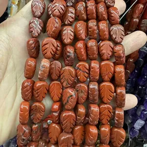 Close-up macro detail of leaf-shaped red jasper carved stone beads for DIY jewelry making