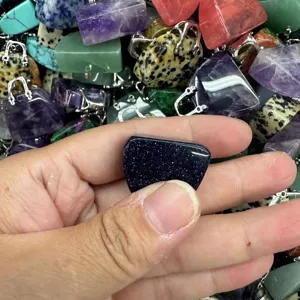 Detailansicht eines funkelnden blauen Handtaschen-Anhängers aus Stein für DIY-Schmuck.