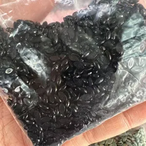 Primo piano di pietre naturali nere marquise da 2x4mm in un sacchetto di plastica