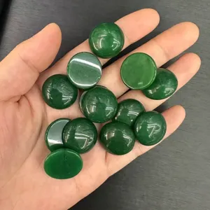 Primo piano di pietre cabochon rotonde verdi lucide per la creazione di gioielli fai-da-te.