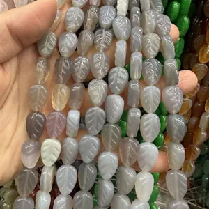 Close-up detail of leaf-shaped natural stone beads showing delicate engraved texture for DIY