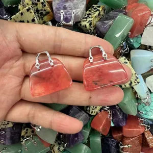 Nahaufnahme von rosafarbenen Naturstein-Handtaschenanhängern für die DIY-Schmuckherstellung