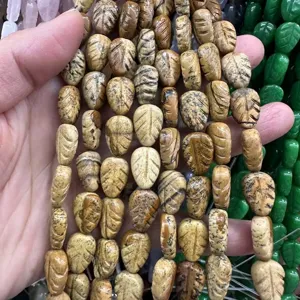 Close-up of engraved leaf-shaped natural stone beads measuring 10x14x6mm for DIY jewelry