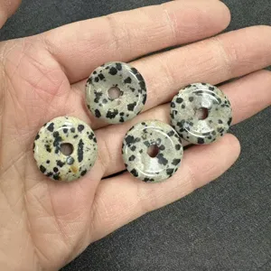 Close-up macro view of four 20mm Dalmatian Jasper natural stone donut beads for DIY jewelry