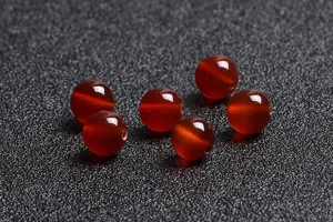 Macro view of natural red agate loose round beads with smooth polished finish.