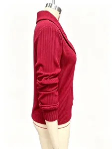 Side detail of red ribbed knit cardigan with lapel collar and three-quarter sleeves.