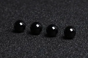 Detailed macro shot of four glossy natural black agate loose beads for DIY jewelry making