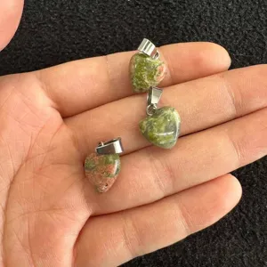 Nahaufnahme von drei 12-mm-herzförmigen Unakit-Natursteinanhängern in der Handfläche gehalten