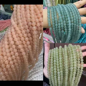 Detailansicht von Naturstein-Rundperlen in Pink und Grün für DIY-Schmuckherstellung.