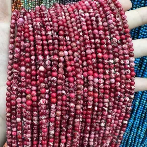 Macro detail of red imperial jasper round beads with natural white marble patterns