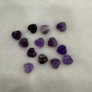 Gros plan sur des pierres d'améthyste naturelles en forme de cœur pour bijoux DIY.
