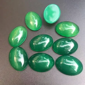 Gros plan sur des cabochons d'agate verte ovale polie pour la création de bijoux DIY