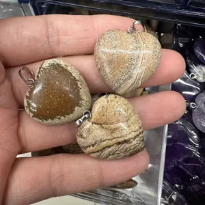 Macro view of 25mm heart-shaped natural stone pendants with unique stripe patterns