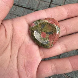 Nahaufnahme eines herzförmigen Unakitschmucksteins mit natürlichen grünen und rosa Mustern