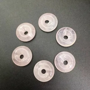 Close-up view of six 15mm natural pink stone Ping An Kou donut beads for jewelry making
