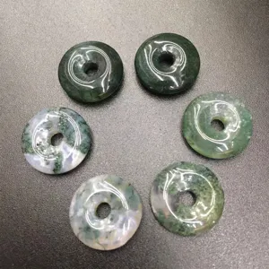 Detail view of 15mm natural moss agate donut beads with unique green patterns