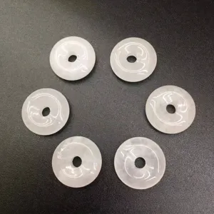 Detailed macro shot of six 15mm white translucent natural stone donut jewelry beads