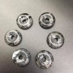 Macro view of 15mm natural grey speckled stone donut pendants for DIY jewelry crafts