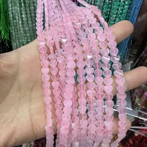 Dettaglio ravvicinato di perline in pietra naturale rosa a forma di cuore da 6mm per gioielli.