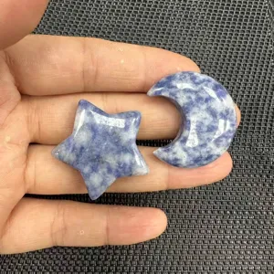 Detailaufnahme von handgehaltenen Anhängern aus blauem Naturstein in Stern- und Mondform